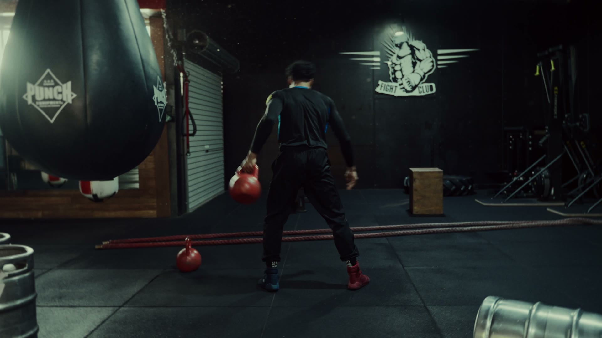 EK training with a kettlebell beside the heavy bag