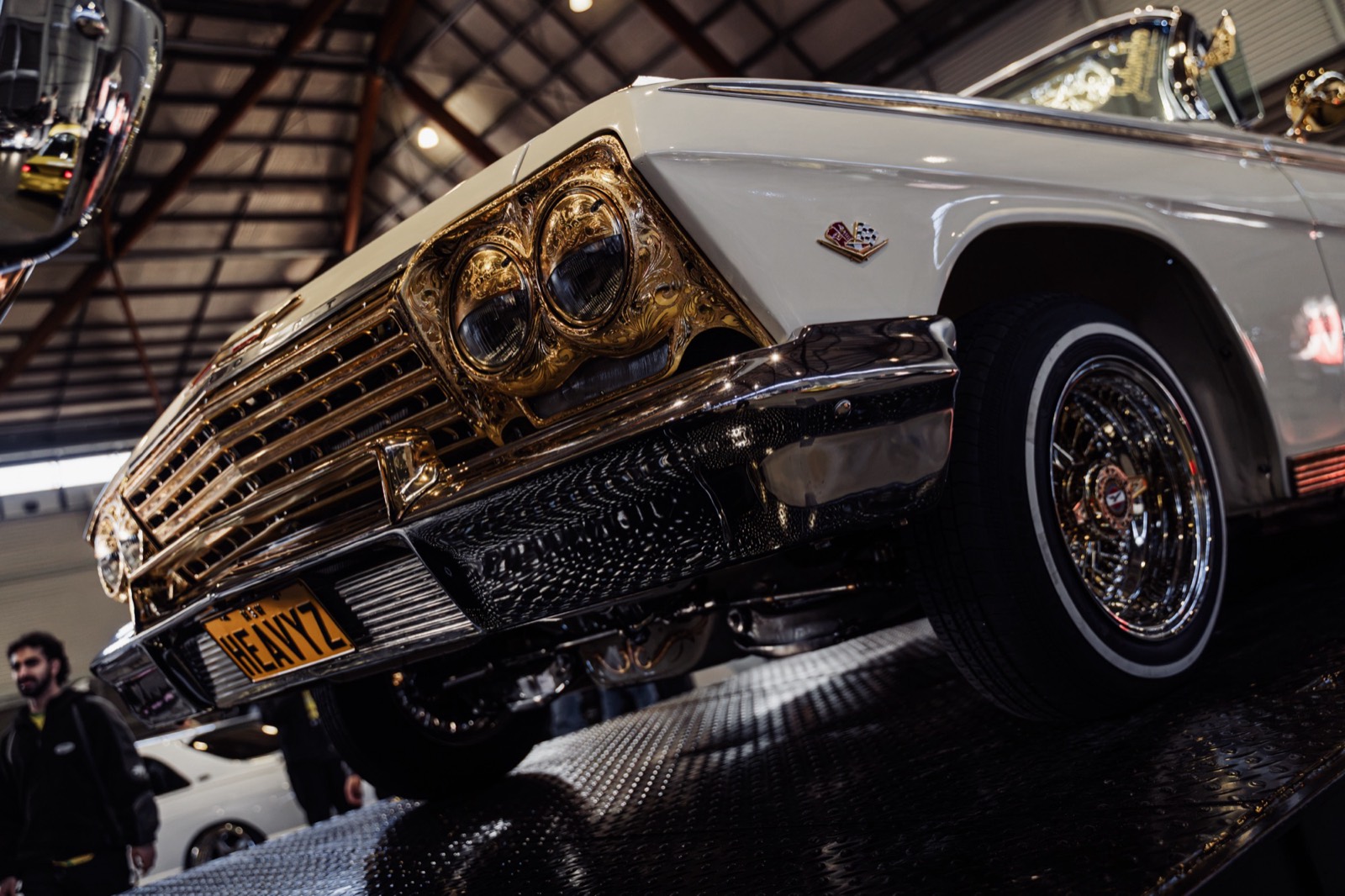 A gold-trimmed lowrider with its front wheel lifted
