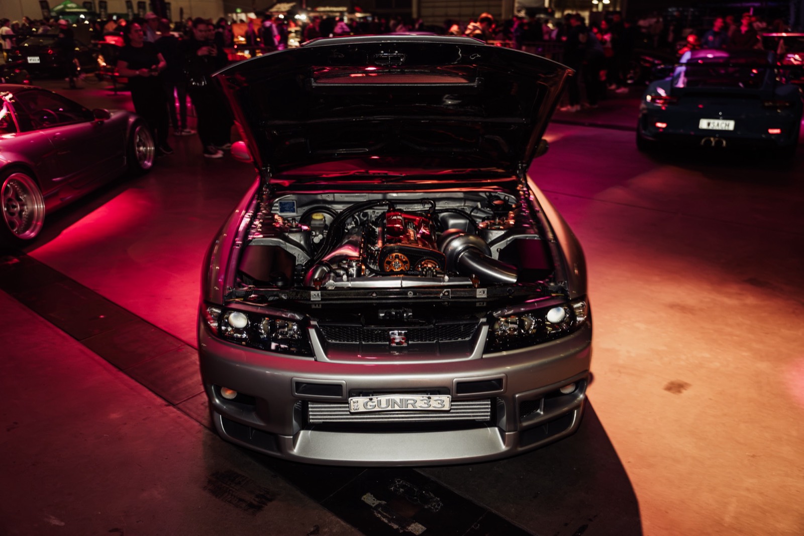 A Skyline with its bonnet up under red light